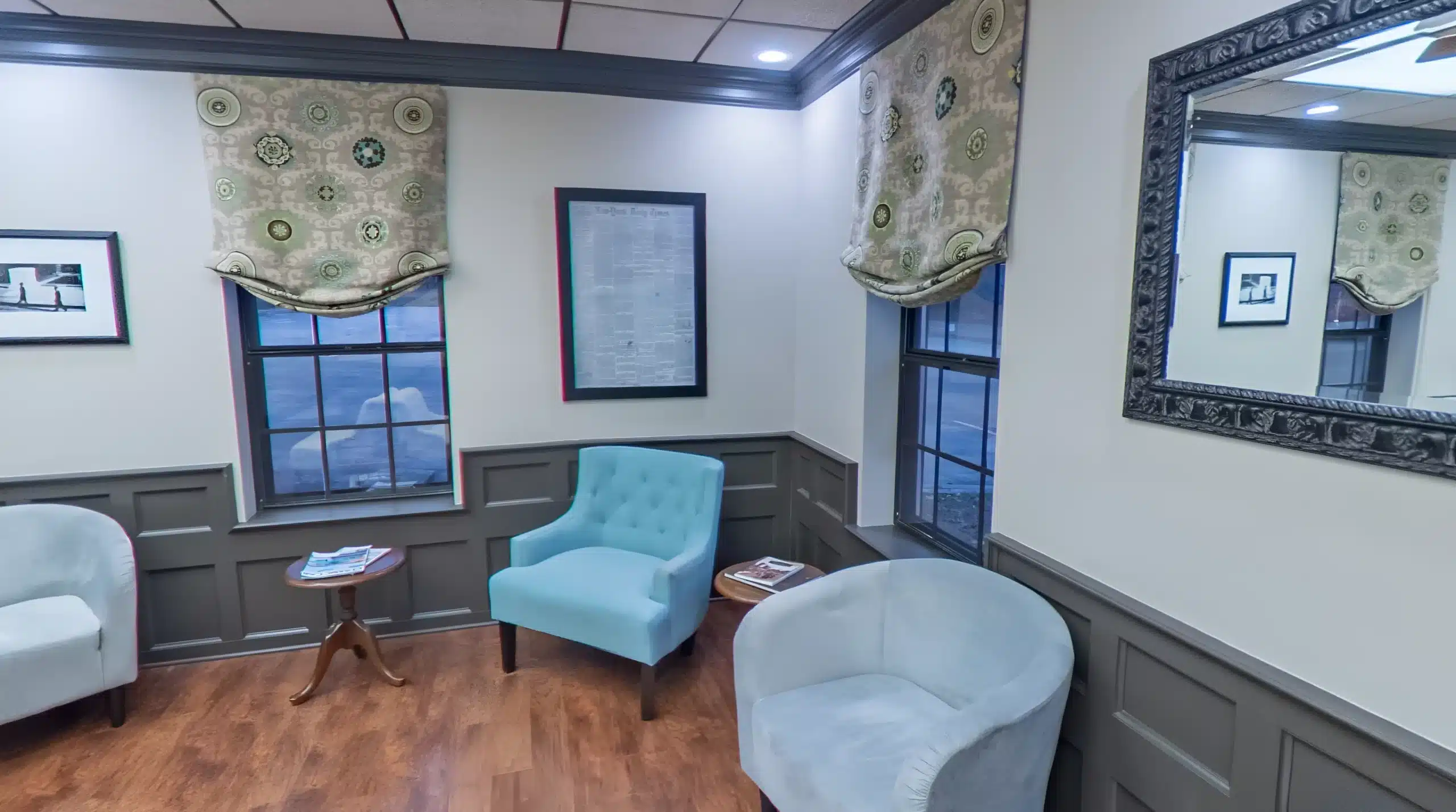Waiting area with light-blue armchairs, framed art and wood floors